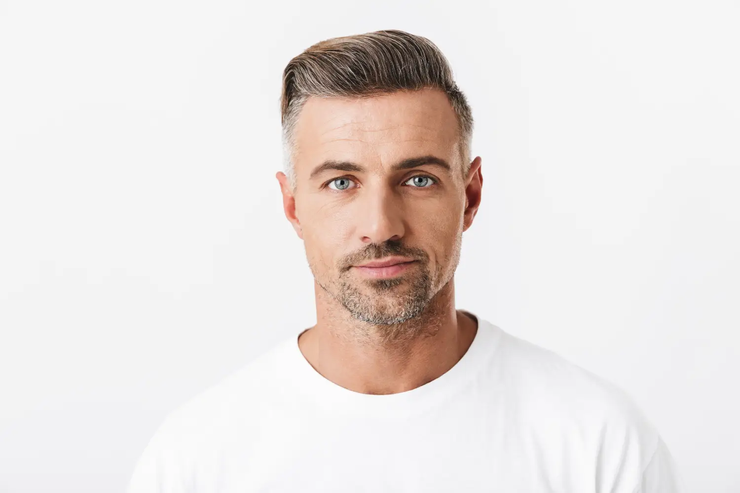 close-up portrait of confident man with short styled hair against light background